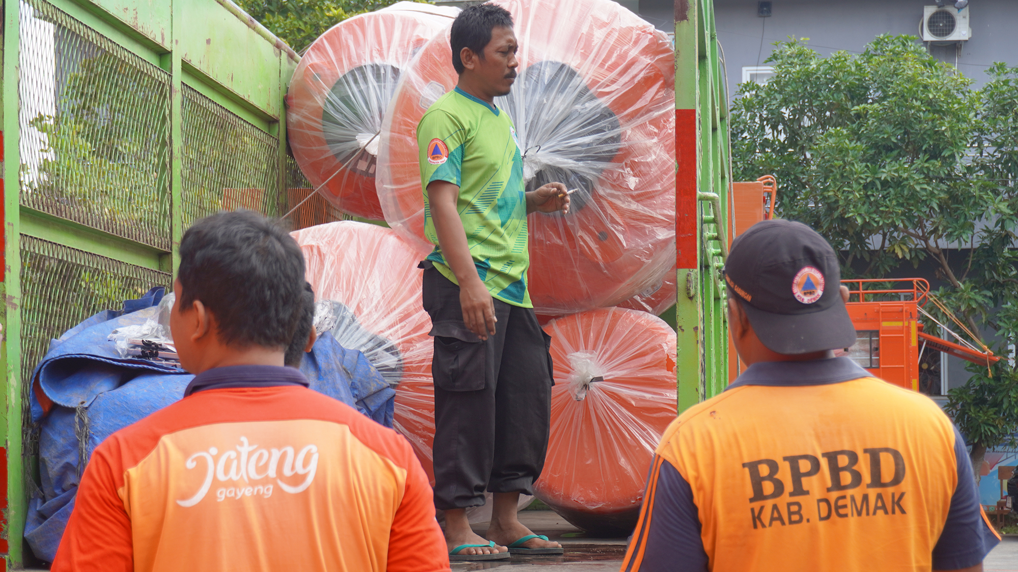 Beberapa orang atau petugas BPBD yang sedang melakukan bongkar muatan produk Tangki Air Pennyu