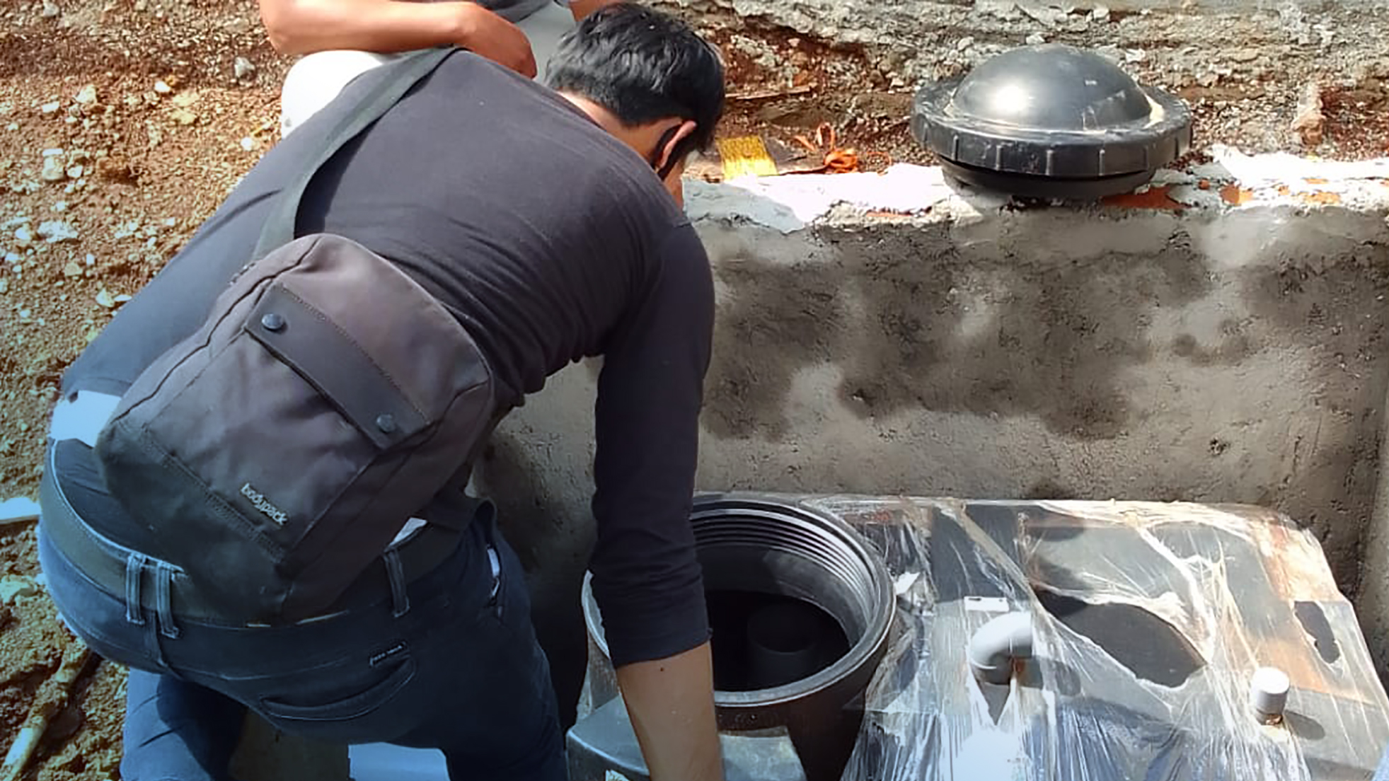 Dua orang sedang mekukan pengecekan instalasi produk Pennyu Bio Septic Tank
